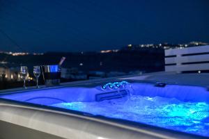 een bad met blauw water en een glas bij Mary Castelia Villa with Jacuzzi in Akrotiri