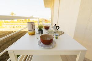 Una mesa blanca con dos tazas encima. en Visitsicilia Rosetta Mare, en Alcamo Marina