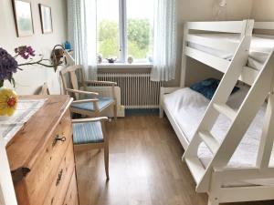 Kleines Zimmer mit einem Etagenbett und einem Schreibtisch. in der Unterkunft Cottage with sea view, Kattviksvägen in Båstad