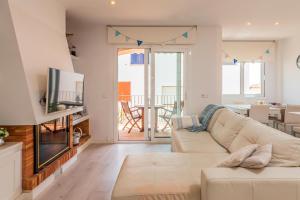 ein Wohnzimmer mit einem Sofa und einem TV in der Unterkunft BN-5 Calella de Palafrugell 4 Pax in Calella de Palafrugell