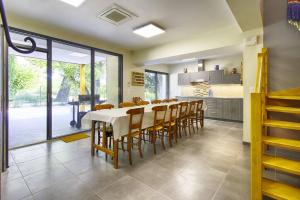 een keuken en eetkamer met een tafel en stoelen bij La maison des Eucalyptus - Piscine, jacuzzis et lac in Orange