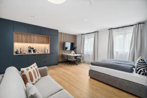 ein Wohnzimmer mit Couch und Schreibtisch in der Unterkunft ANYTIME - Rohrbach Apartments in Friedrichshafen