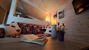 a table with a book and a candle and a glass of wine at Sauerland-Tinyworld - Ihr Tiny Ferienhaus im Sauerland am Diemelsee in Diemelsee