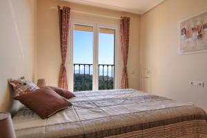 a bedroom with a bed and a large window at Precioso bungalow con piscina - MASCARAT in Altea la Vieja