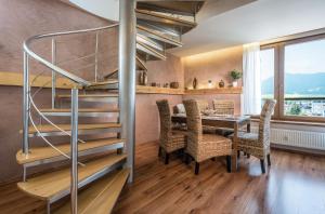 a dining room with a spiral staircase and a table and chairs at Apartments Sofia plus in Liptovský Mikuláš