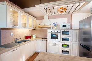 a kitchen with white cabinets and a sink at Apartments Sofia plus in Liptovský Mikuláš