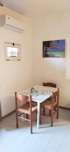 uma mesa de jantar com 2 cadeiras e uma mesa branca em GardenHouse em Cagliari
