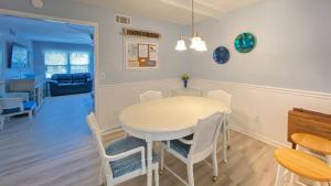 una cucina e una sala da pranzo con tavolo e sedie bianchi di GOLDEN DAYS DUPLEX Duplex a Jekyll Island Altre 11 foto