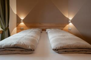two beds in a room with lights on the wall at Bait Martin Appartamento 3 in Livigno