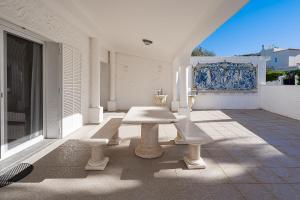 un patio con mesa y bancos en un edificio en Casa Nela, en Carvoeiro