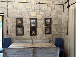 a stone wall with a wooden table and blue chairs at Elia Home in Lefkogeia
