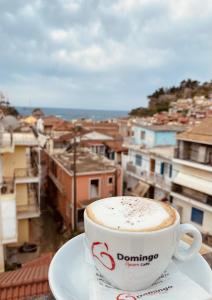 a cup of coffee sitting on a plate on a table at Central Hotel in Parga