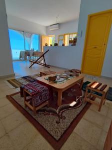 a living room with a table and a rug at Maison vue mer, île de Zembra et montagne en Tunisie - Elhaouaria in El Haouaria