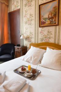 a tray of food sitting on top of a bed at Hotel de la Poste in Corps