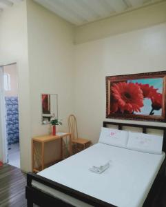 a bedroom with a bed with a painting on the wall at WJV INN CONSOLACION in Tugbongan