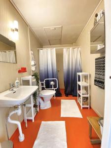 ein Badezimmer mit einem weißen Waschbecken und einem WC in der Unterkunft Cottage with sea view, Kattviksvägen in Båstad