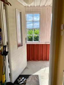 eine offene Tür zu einem Zimmer mit Fenster in der Unterkunft Cottage with sea view, Kattviksvägen in Båstad