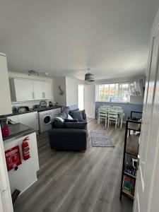 uma sala de estar com um sofá e uma cozinha em Ruby's Den em Carbis Bay