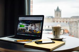 a laptop computer sitting on a table with a cup of coffee at Staycity Aparthotels Dublin Castle in Dublin