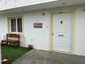 a white house with a white door and a bench at Galini Relax Suite in Rafina