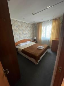 um quarto com uma cama grande num quarto em Victoria Hotel em Aktau
