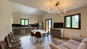 a kitchen and living room with a table and chairs at Chalet Anthony in Faucon-de-Barcelonnette