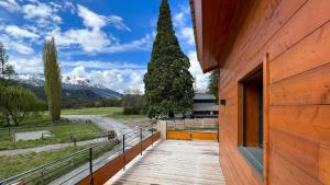 a wooden walkway next to a building with a tree at Chalet Anthony in Faucon-de-Barcelonnette