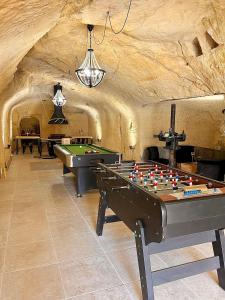 um quarto com duas mesas de bilhar numa caverna em A l'Ombre d'Azay - Demeure d'Hôtes em Azay-le-Rideau