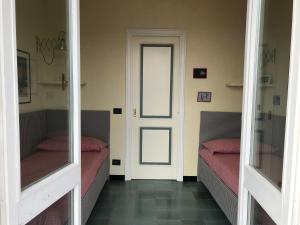 a room with two beds and a door with mirrors at Solimano 50 in Santa Margherita Ligure