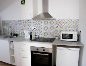 a kitchen with a counter top with a microwave at Apartamento São Miguel - Santa Catarina Place in Ponta Delgada