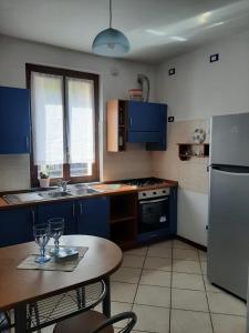 a kitchen with blue cabinets and a table with glasses on it at La casa al lago BMOR love&lake in Mezzegra +51 photos