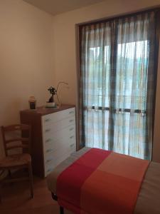 a bedroom with a bed and a dresser and a window at La casa al lago BMOR love&lake in Mezzegra +51 photos