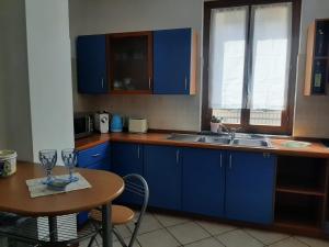 a kitchen with blue cabinets and a table and a sink at La casa al lago BMOR love&lake in Mezzegra