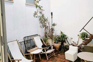 eine Terrasse mit Stühlen, Tischen und Topfpflanzen in der Unterkunft house with patio carmel market in Tel Aviv