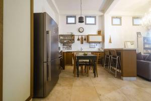 eine Küche mit einem Kühlschrank aus Edelstahl und einem Tisch in der Unterkunft house with patio carmel market in Tel Aviv