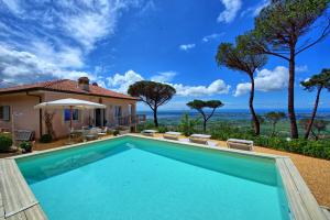 a swimming pool in front of a house with the ocean at Casarosa di Mariasole by PosarelliVillas in Montigiano