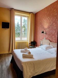 a bedroom with a large bed with towels on it at Domaine des Cèdres - Hôtel, gîtes et insolites in Villebois