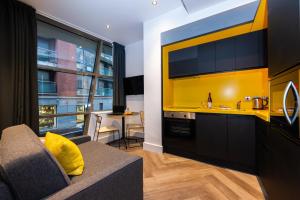 a living room with a couch and a yellow kitchen at Staycity Aparthotels Dublin Castle in Dublin