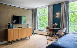 a bedroom with a bed and a tv and a table at Heuvelsuites in Oosterhout