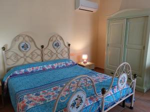a bedroom with a bed with a blue comforter at Agriturismo Agrisole in Olbia