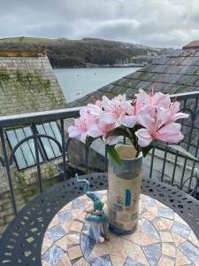 een vaas met roze bloemen op een tafel bij The Captain’s 4 Bed Penthouse in Fowey