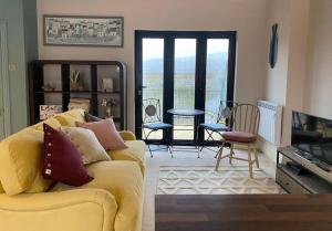 a living room with a yellow couch and a table at The Captain’s 4 Bed Penthouse in Fowey