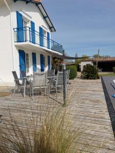 una terraza con sillas y una casa en maison de campagne proche des plages, en Saint-Romain-de-Benet