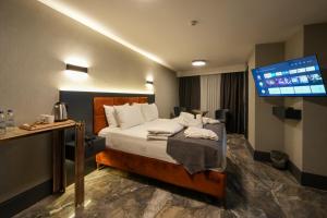 pokój hotelowy z łóżkiem i telewizorem z płaskim ekranem w obiekcie Hotel Kurucesme Business w Stambule