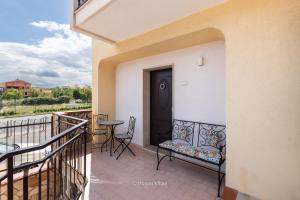a balcony with a black door and a table and chairs at House&Villas - Casa Amica in Avola