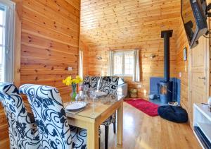 a dining room with a table and chairs and a stove at Silver Birch Lodge in Middleton