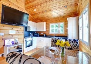 a kitchen with a table and a tv on the wall at Silver Birch Lodge in Middleton