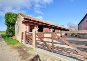a house with a wooden fence and a gate at Silver Birch Lodge in Middleton