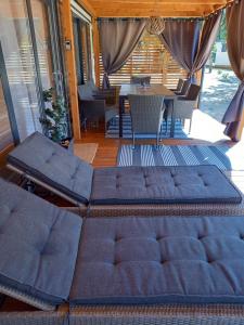 a couch on a porch with a table and chairs at Mobile Home Agava 2 in Biograd na Moru