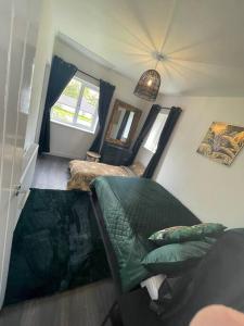 a living room with a green couch and a mirror at The Stables,Ashley in Ashley